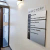 ADA Signs / Wayfinding 3 Custom interior building directory sign mounted in a commercial office lobby listing tenant suites by floor, with a modern acrylic and metal frame design