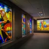 Custom printed window vinyl designed to replicate the appearance of traditional stained glass, applied to interior glass panels with colorful translucent patterns and decorative motifs
